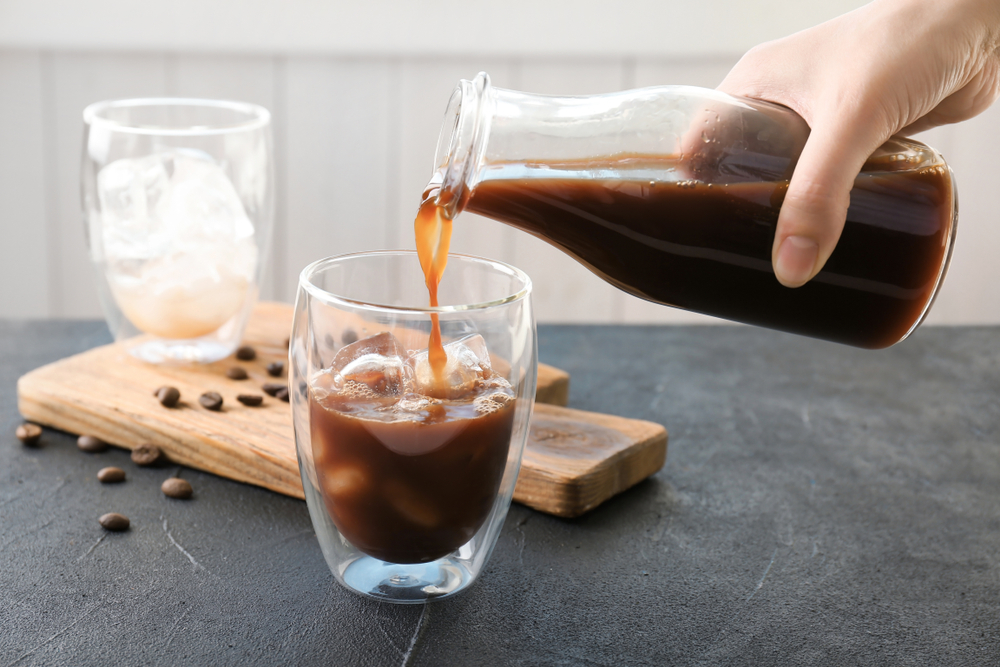 Woman pouring cold brew coffee into a glass