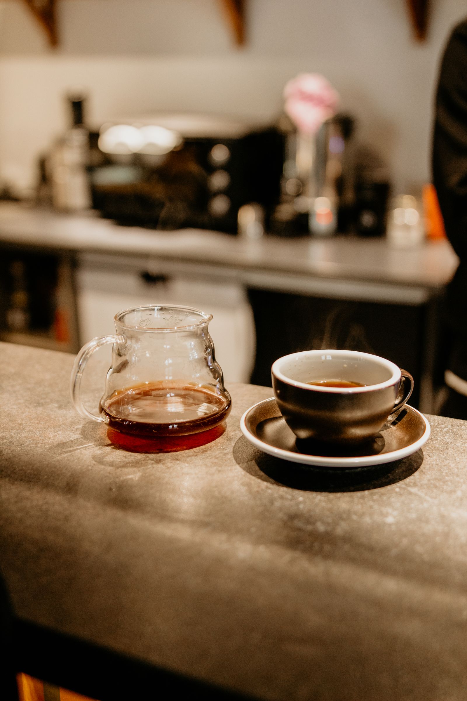 Coffee cup and carafe on a counter; illustrative coffee moment, not a K-Express product or descaling step.